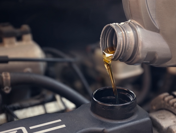 pouring oil from a bottle inside the engine
