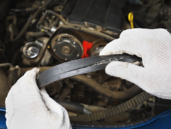 mechanic holding a broken belt