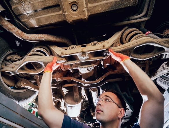 mechanic checking car for any strut or shocks replacement needed